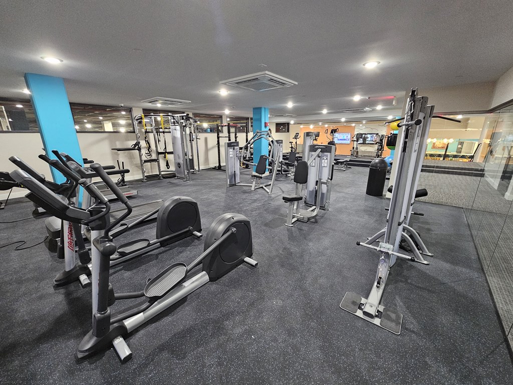 a gym with cardio equipment and weights in a building