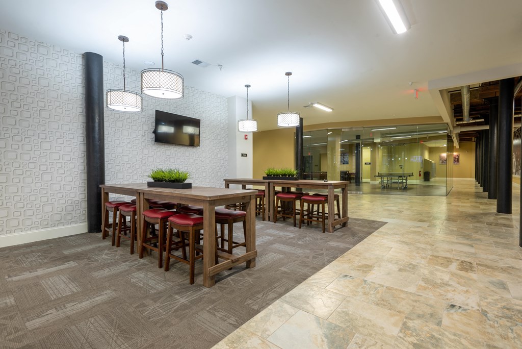 a lobby with tables and chairs and a tv