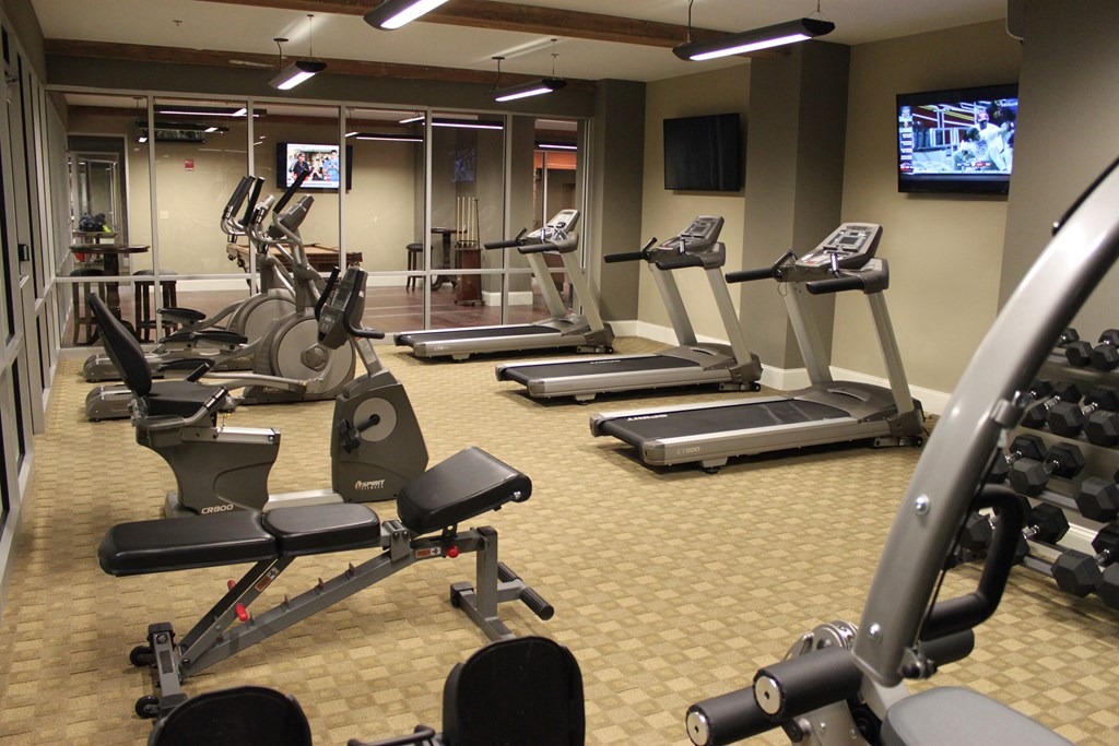 a gym full of exercise equipment and a tv