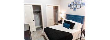 a bedroom with a large bed with a blue headboard and black and white bedding