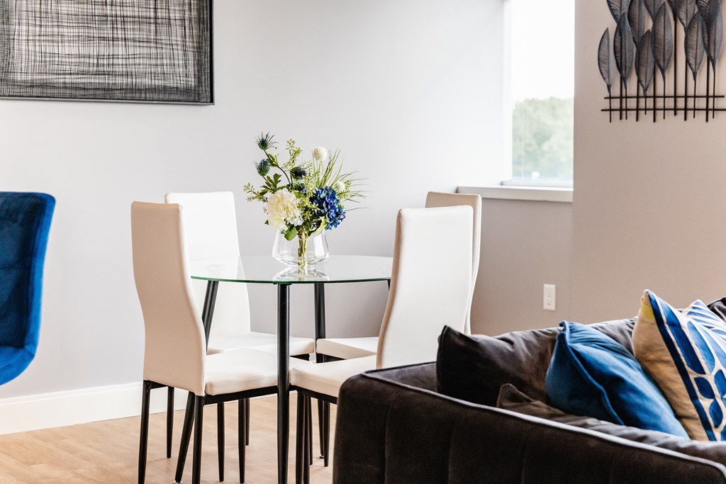 a dining room with a glass table and white chairs