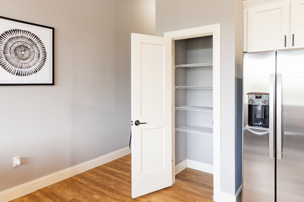 a small pantry in a kitchen with a refrigerator and a coffee maker
