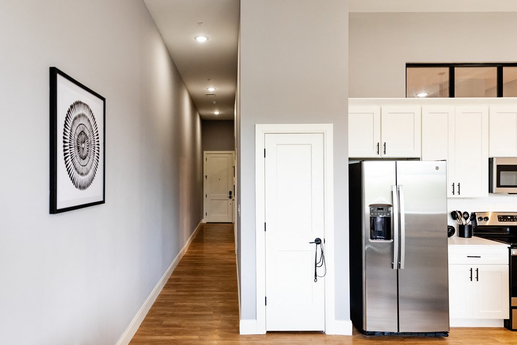 a kitchen with white cabinets and a stainless steel refrigerator