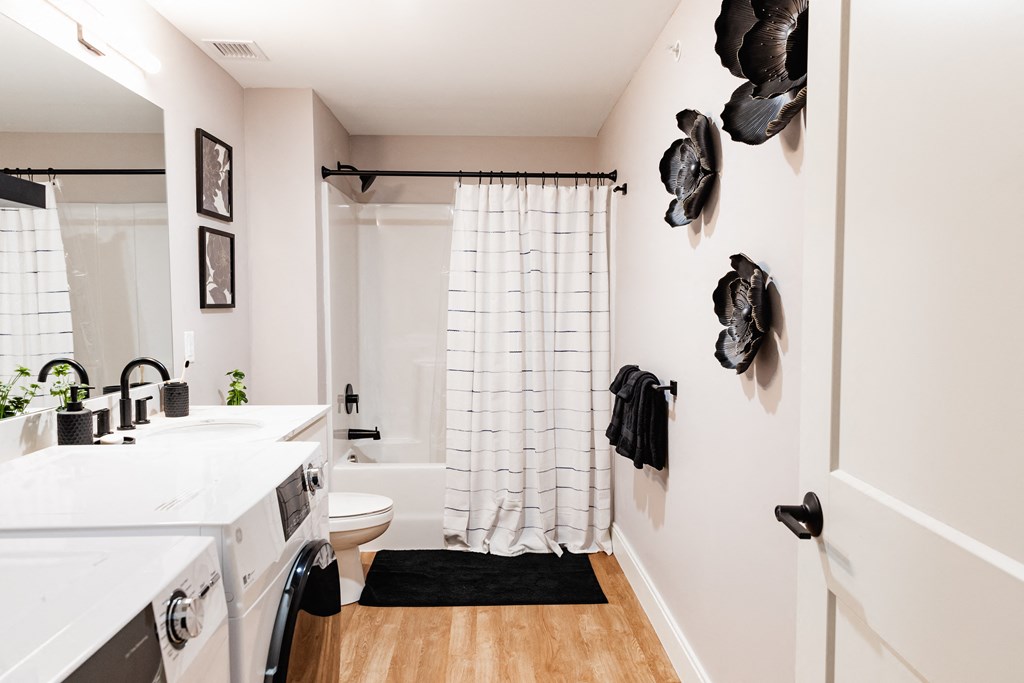 a bathroom with white walls and black decorations on the wall