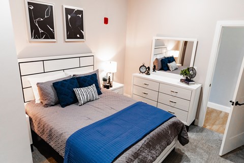 a bedroom with a bed and a dresser with a mirror