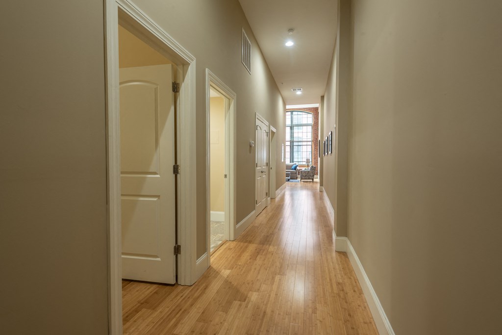 a hallway with wood floors and white walls and doors