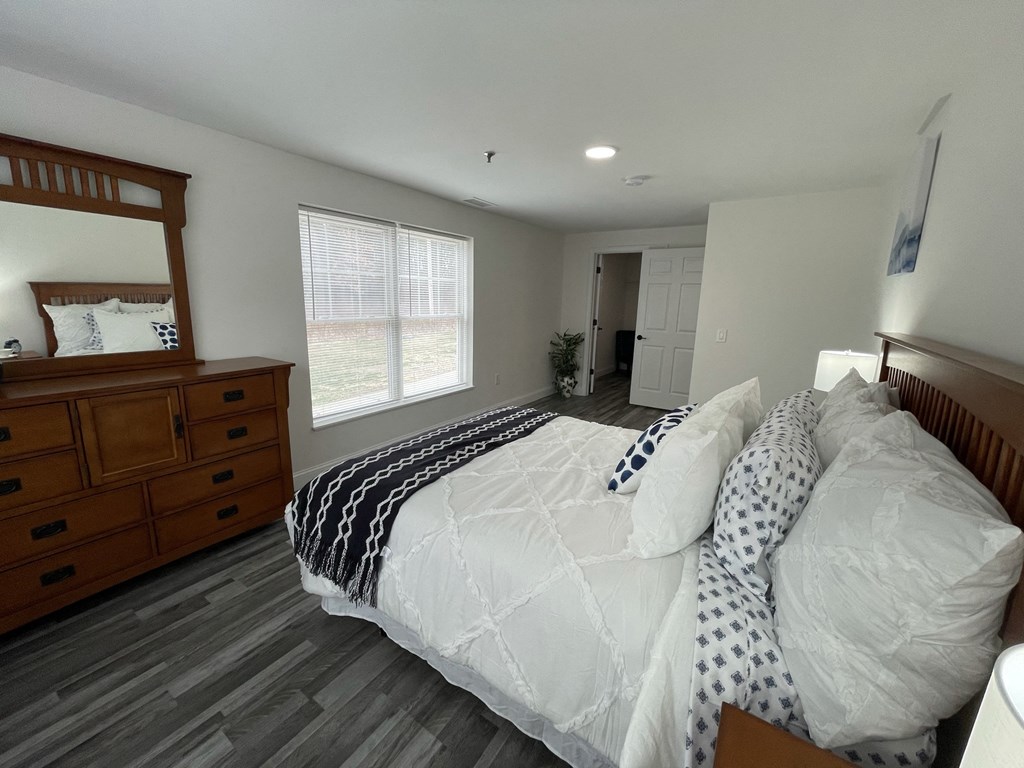 a bedroom with a bed and a dresser and a window