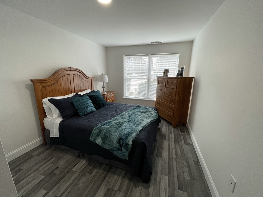 a bedroom with a bed and a dresser and a window