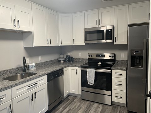 a kitchen with stainless steel appliances and white cabinets