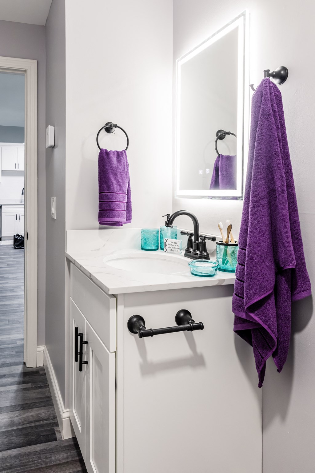 a bathroom with a purple towel hanging next to a sink in a 555 waverly unit