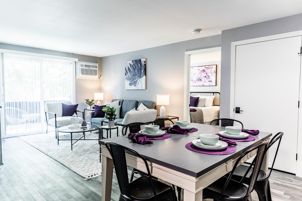 a living room with a dining room table and chairs and a couch and chair in the background