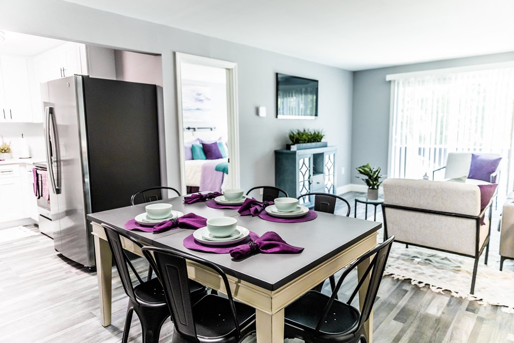 an open floor plan with a dining table and chairs and a living room with a couch and