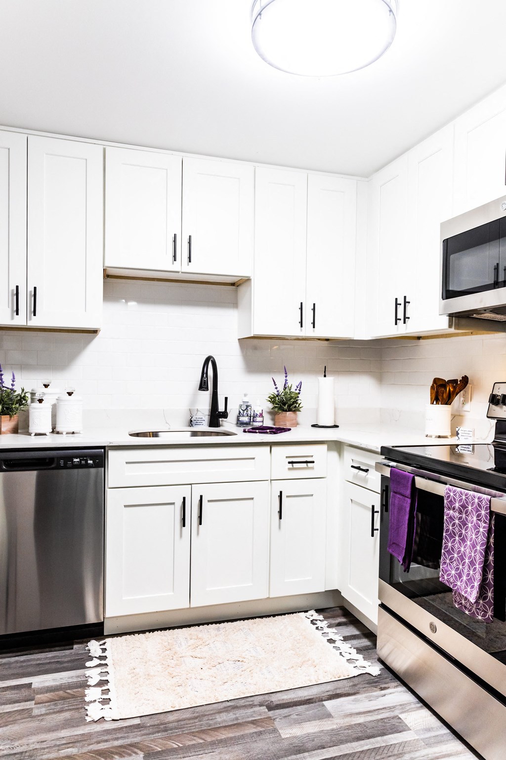 a kitchen with white cabinets and stainless steel appliances