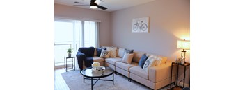 A living room with a couch, a coffee table, and a bicycle picture on the wall.