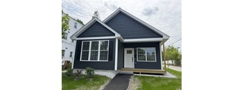 A small house with a white door and windows.