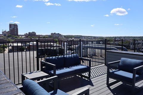 A patio with a table and chairs overlooking a city.