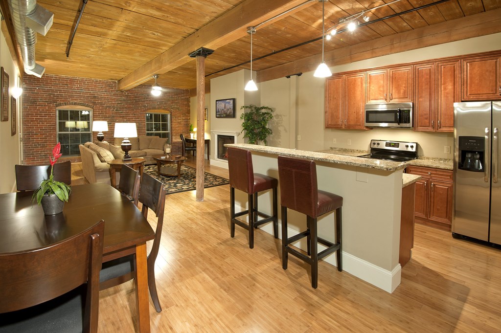 an open kitchen and dining area with a bar and a living room