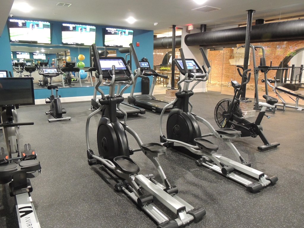 a gym with several exercise bikes and weights on the floor