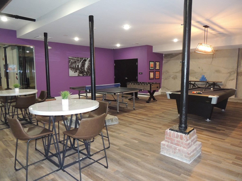 a gaming room with tables and chairs and a pool table