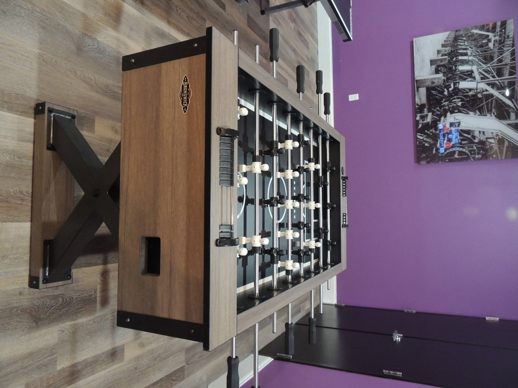 a cabinet with wine bottles on it in a room with a purple wall