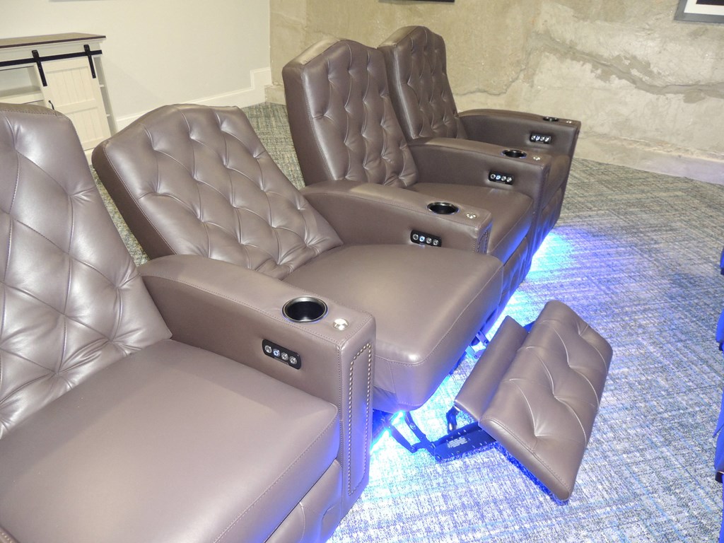 a group of leather chairs and couches in a living room