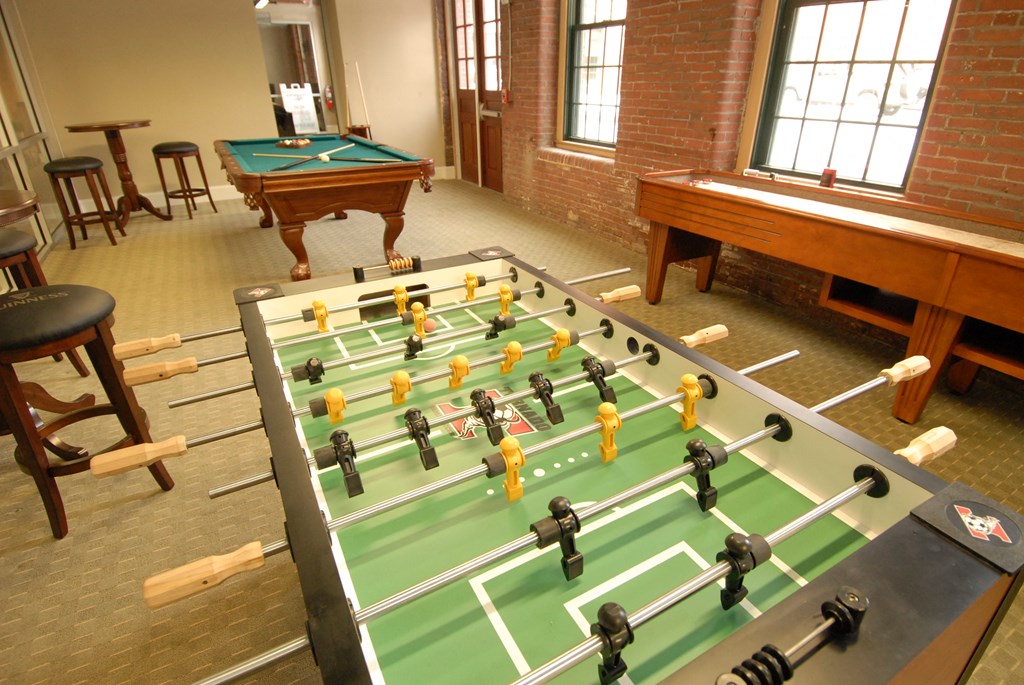 a game room with a foosball table and a pool table