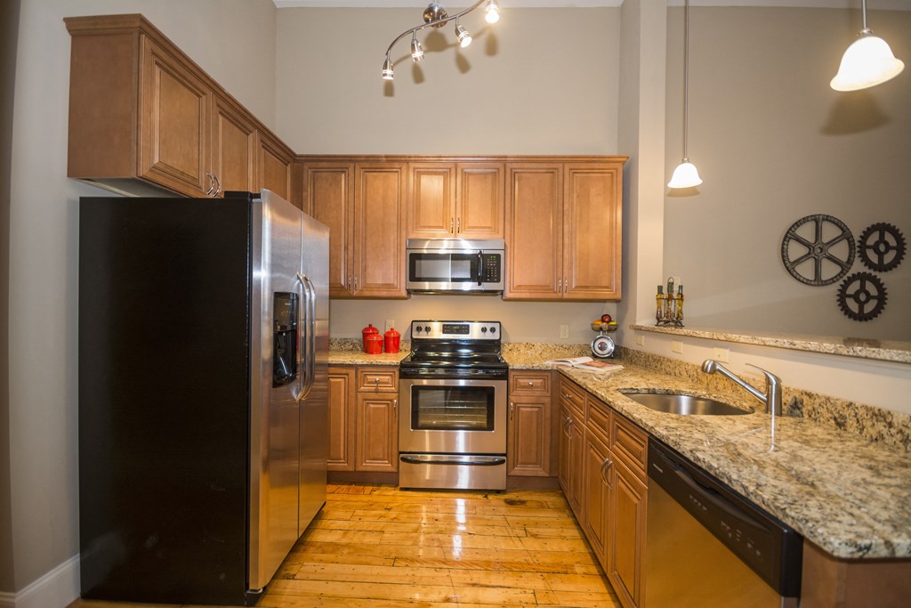 a kitchen with wooden cabinets and granite counter tops and stainless steel appliances