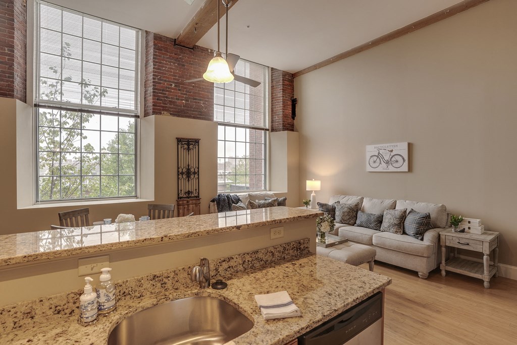 an open living room with a kitchen and a large window