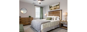 A bedroom with a large bed, a wooden headboard, and a painting on the wall.