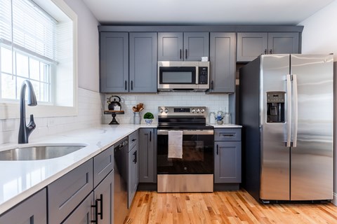 A kitchen with a stainless steel refrigerator and a white countertop.
