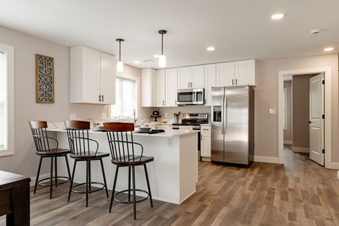 A kitchen with white cabinets and a refrigerator.