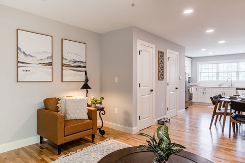 A living room with a brown chair and two landscape paintings on the wall.