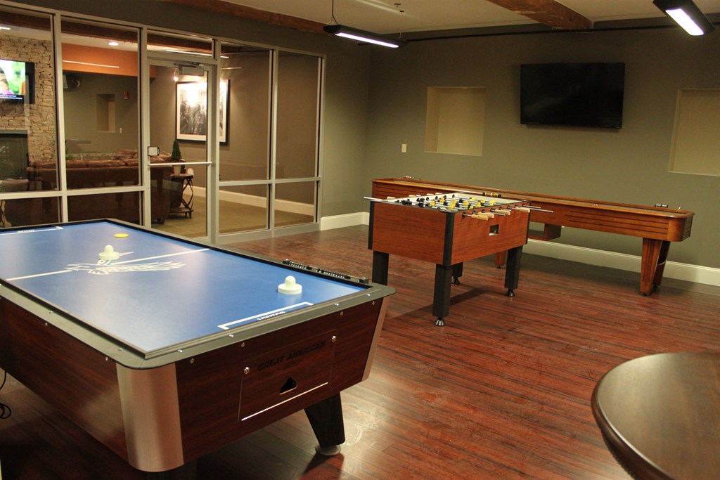 a game room with two pool tables and a tv
