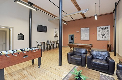 a game room with a pool table and leather furniture