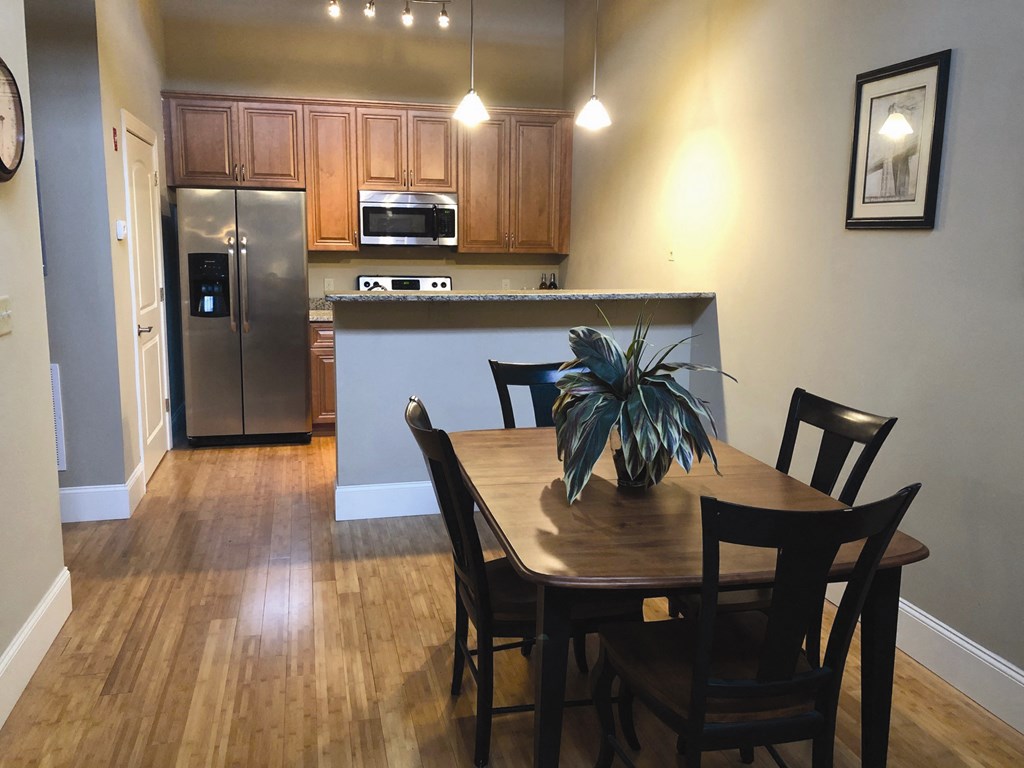 a dining room and kitchen with a table and chairs