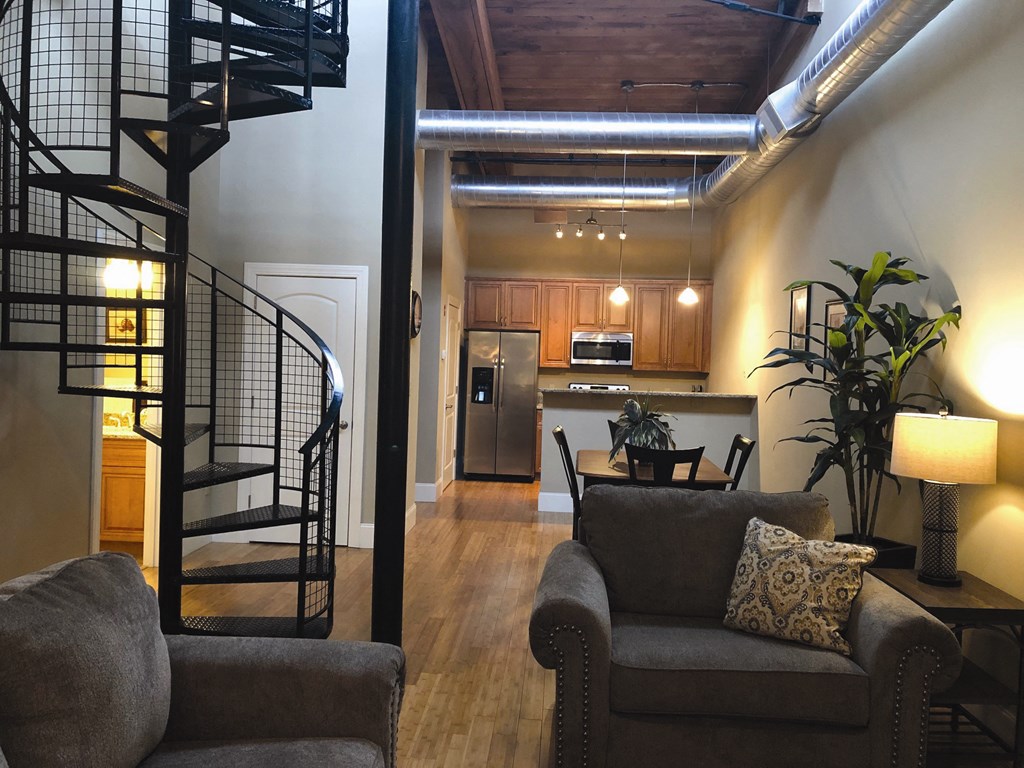 a living room and kitchen with a spiral staircase