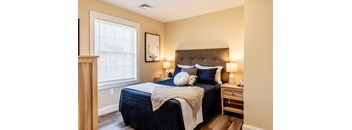 A bedroom with a large bed and a wooden headboard.