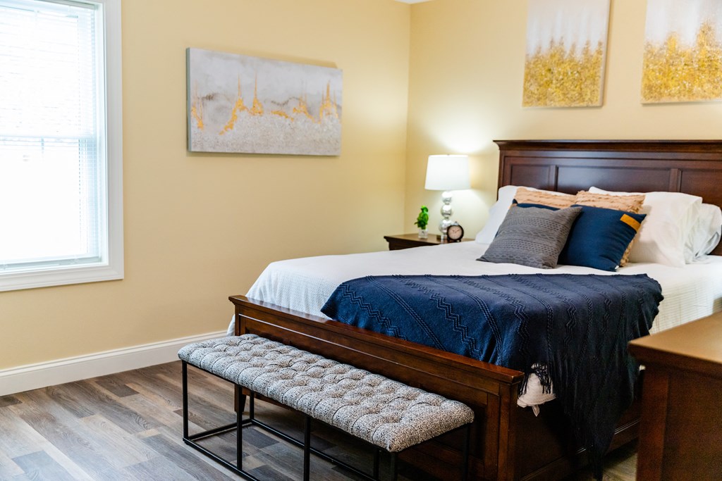 a bedroom with a large bed and a bench at the foot of the bed