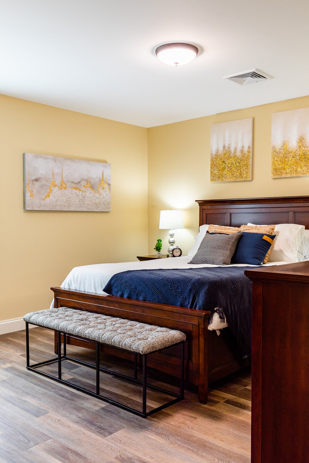 a bedroom with a bed and a bench at the foot of the bed