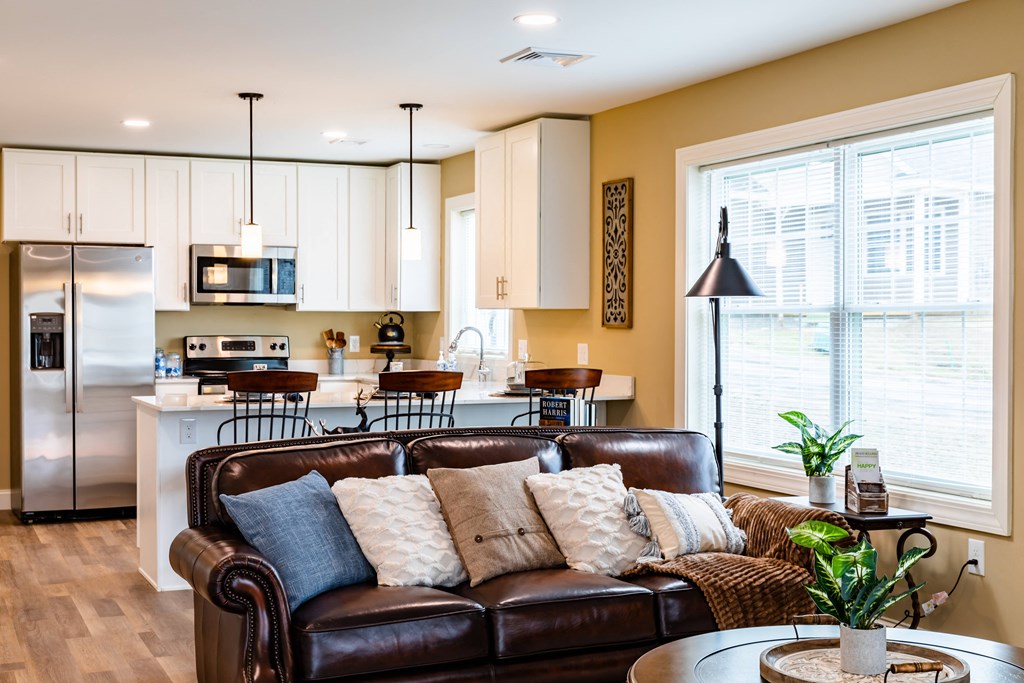 a living room with a leather couch and coffee table in front of a large window
