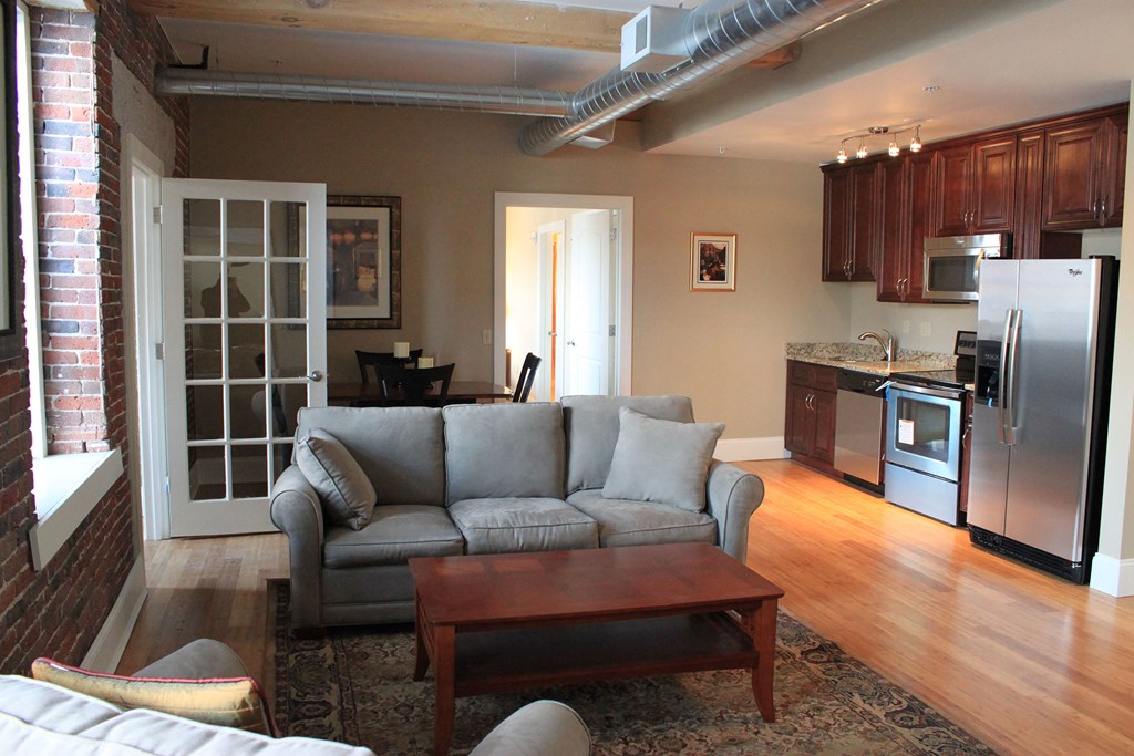 a living room with a couch and a coffee table in front of a kitchen