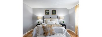 A bedroom with a large bed and two lamps on either side of the bed.