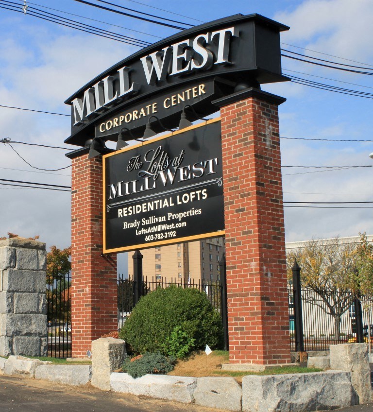 a sign for the mill west corporate center in front of a gate