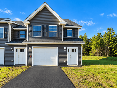 A two-story house with a garage and a driveway.