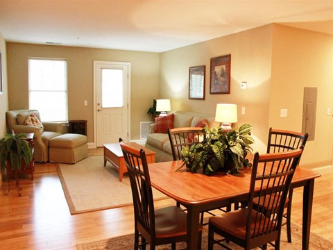 a living room and dining room with a table and chairs