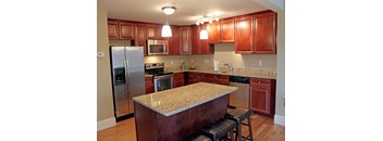 A kitchen with wooden cabinets and granite countertops.