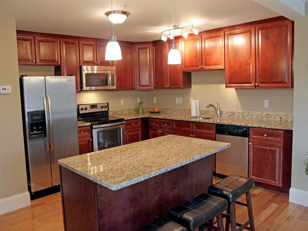 a kitchen with a granite counter top and a stainless steel refrigerator