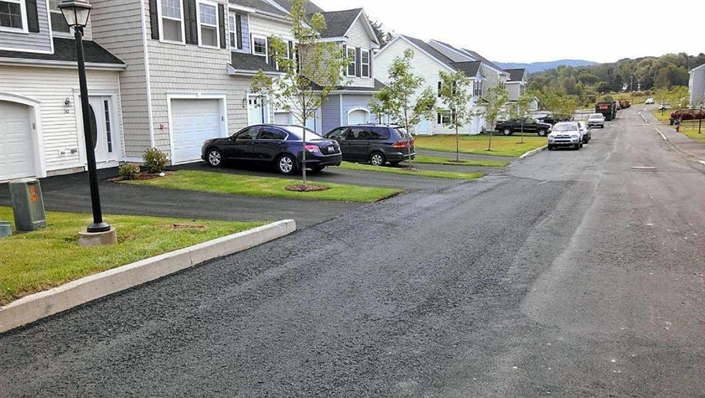 a street with cars parked in front of houses