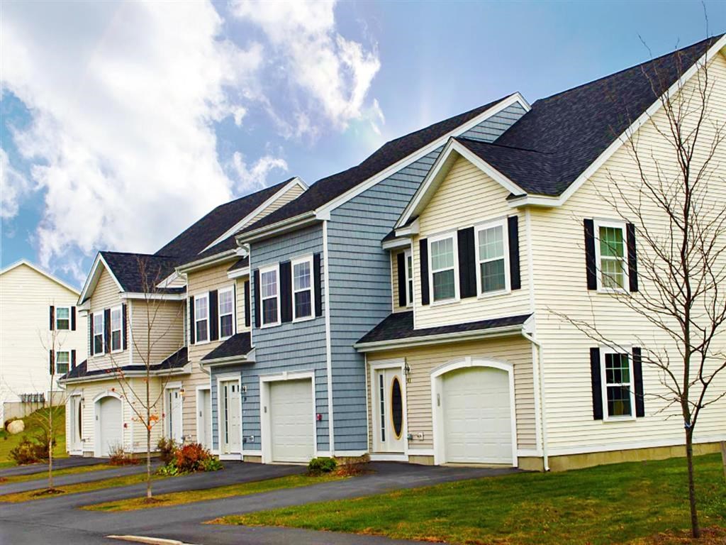 a row of houses with white siding and black roofs