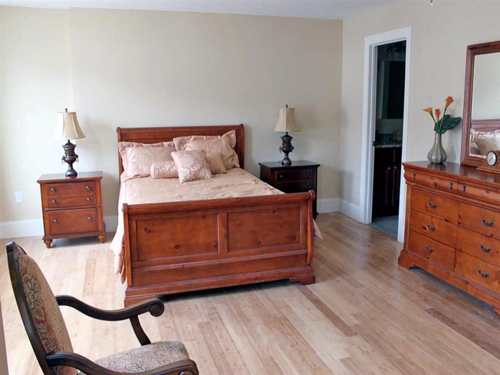 a bedroom with a bed and two dressers